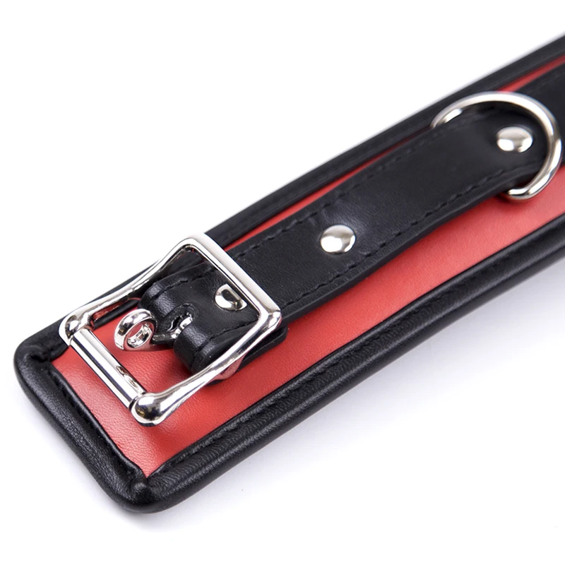 A black leather BDSM collar with a heavy iron chain link and soft sponge interior padding.