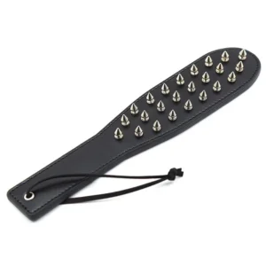 Close-up of a dual-sided black leather spanking paddle and spiked whip for BDSM adult games.