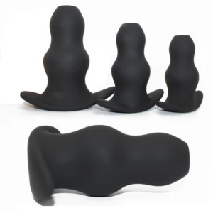 Three different sizes of black hollow silicone anal plugs and speculums for prostate massage and dilation.