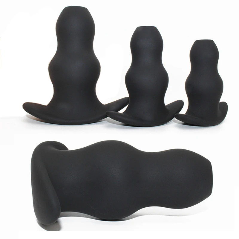 Three different sizes of black hollow silicone anal plugs and speculums for prostate massage and dilation.