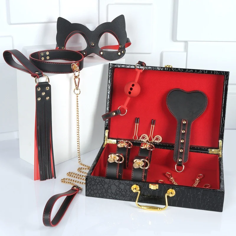 A professional luxury bondage kit featuring black handcuffs, a neck collar, a mouth gag, and an erotic whip on a clean background.