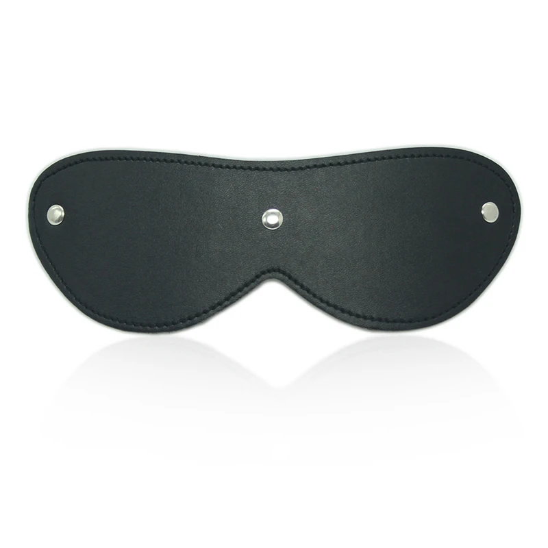 Close-up of a black leather eye mask blindfold with adjustable straps for adult fetish games and sensory deprivation.