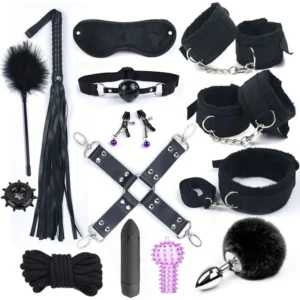 A comprehensive BDSM kit featuring black nylon handcuffs, a sex whip, a mouth gag, and a grey rabbit tail anal plug on a neutral background.
