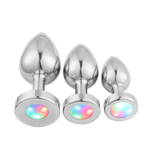 A polished stainless steel anal plug with an illuminated LED base for adult sensory play.