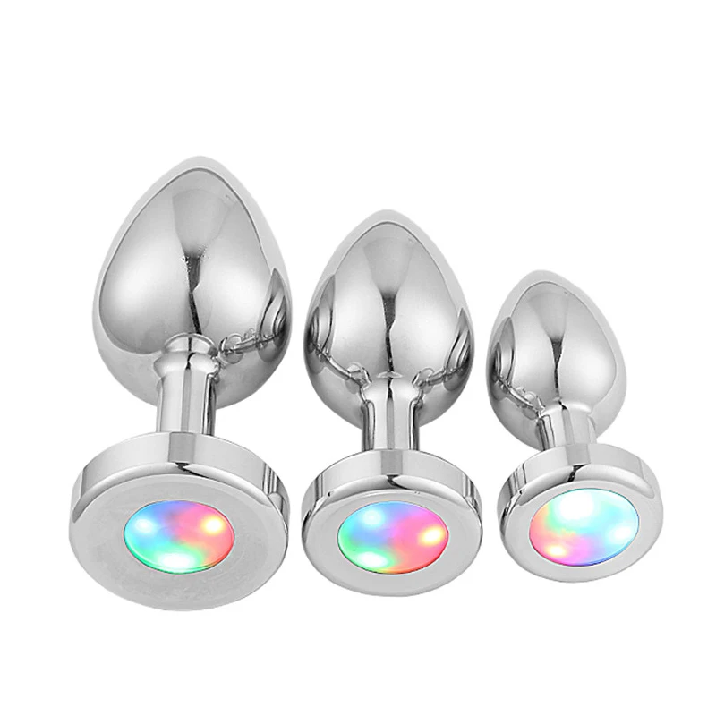 A polished stainless steel anal plug with an illuminated LED base for adult sensory play.