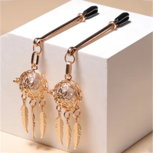 Silver-tone metal nipple clamps with red silk tassels and small decorative bells for BDSM play.