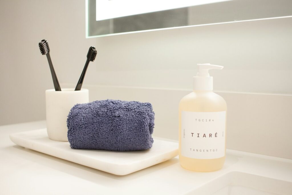 Clean minimal bathroom counter with soap dispenser and folded towel representing hygiene and self-care